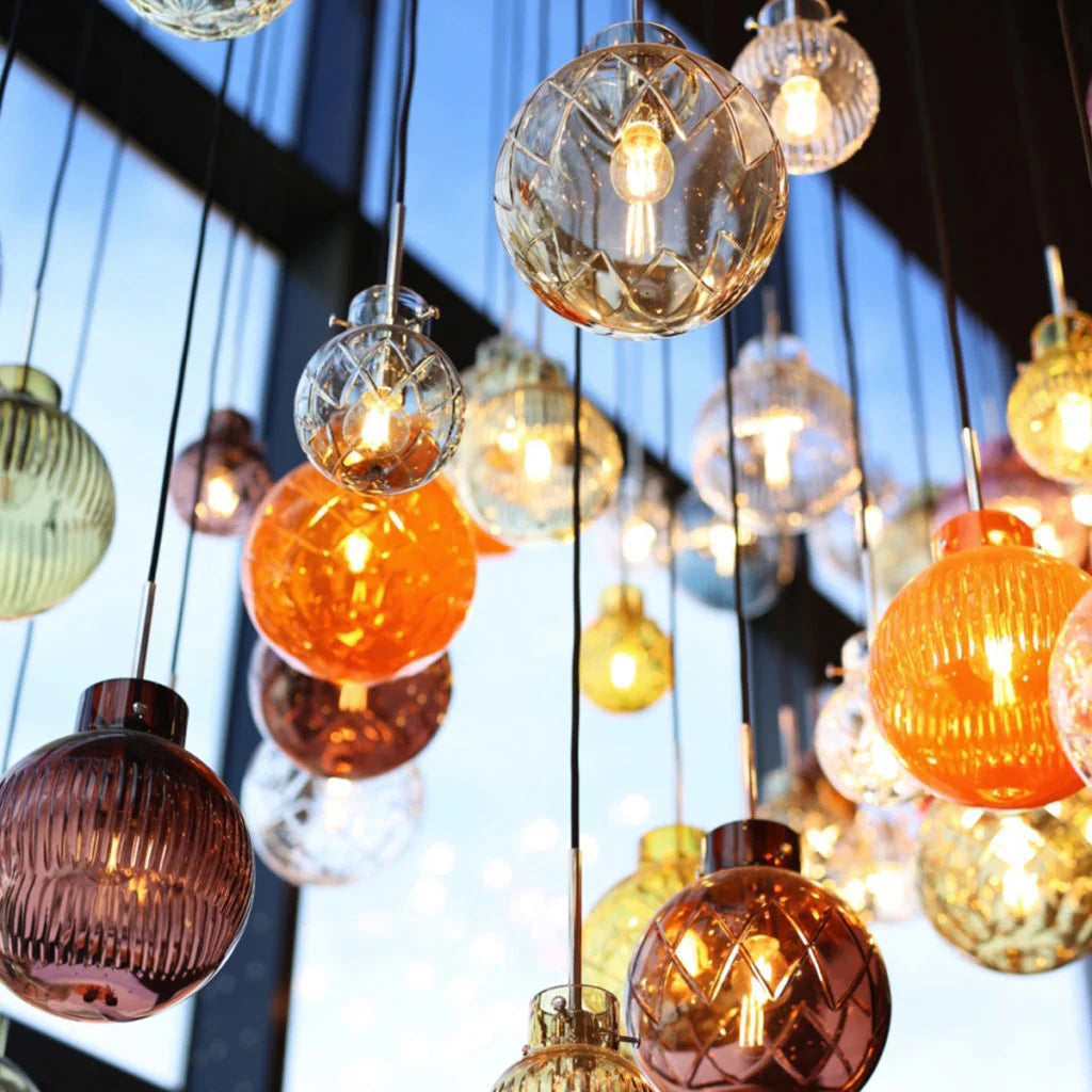 Nærbilde av krystallkuler, i ulike farger og slipemønster, i trappen opp til Galleri 2 på Hadeland Glassverks opplevelsessenter.