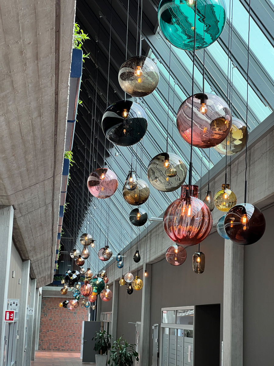 Munnblåste pendellamper fra Arkiv-serien til Hadeland Glassverk installert i Equinors hovedkontor.