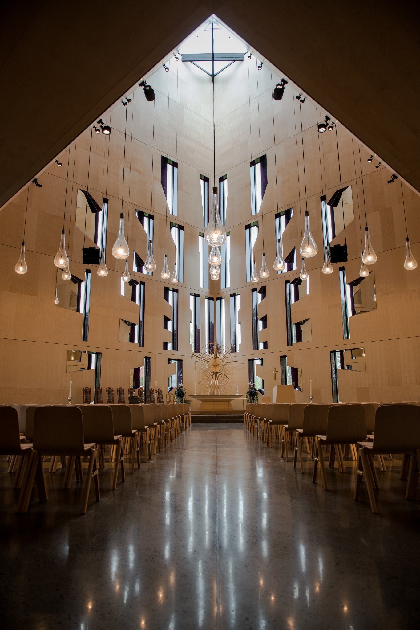 Glasspendler munnblåst på Hadeland Glassverk henger fra taket i Våler Kirke