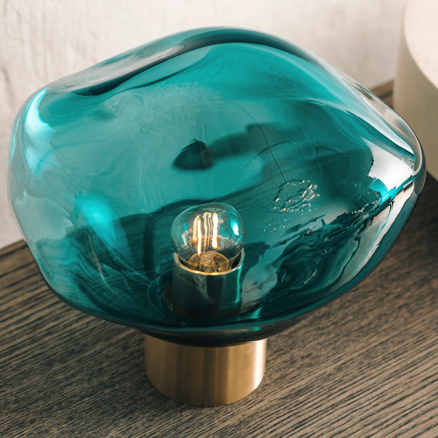 Nærbilde av Crystal Stone bordlampe i fargen blågrønn fra Hadeland Glassverk. Bordlampen vises med messing fot.