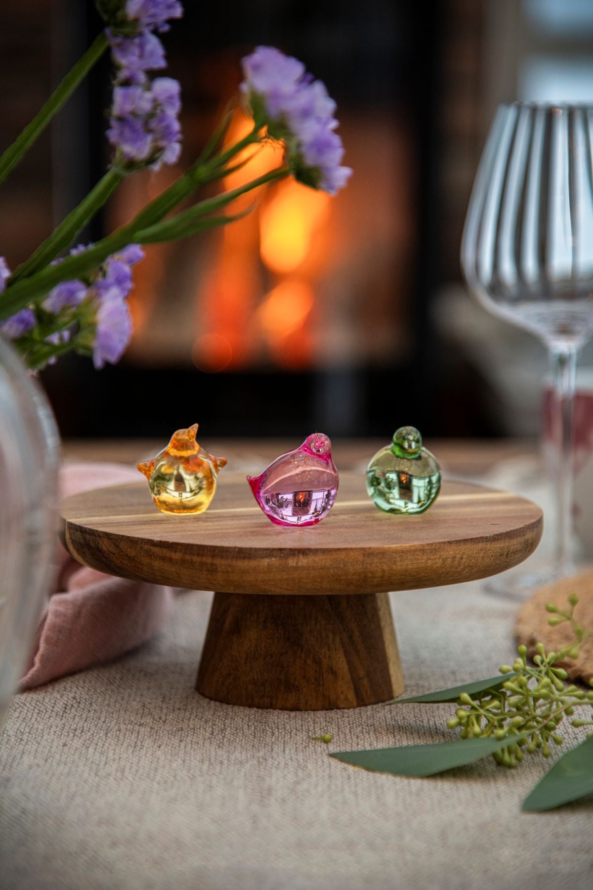 Kyllinger i krystall i fargene rosa, gul og grønn på et dekket påskebord