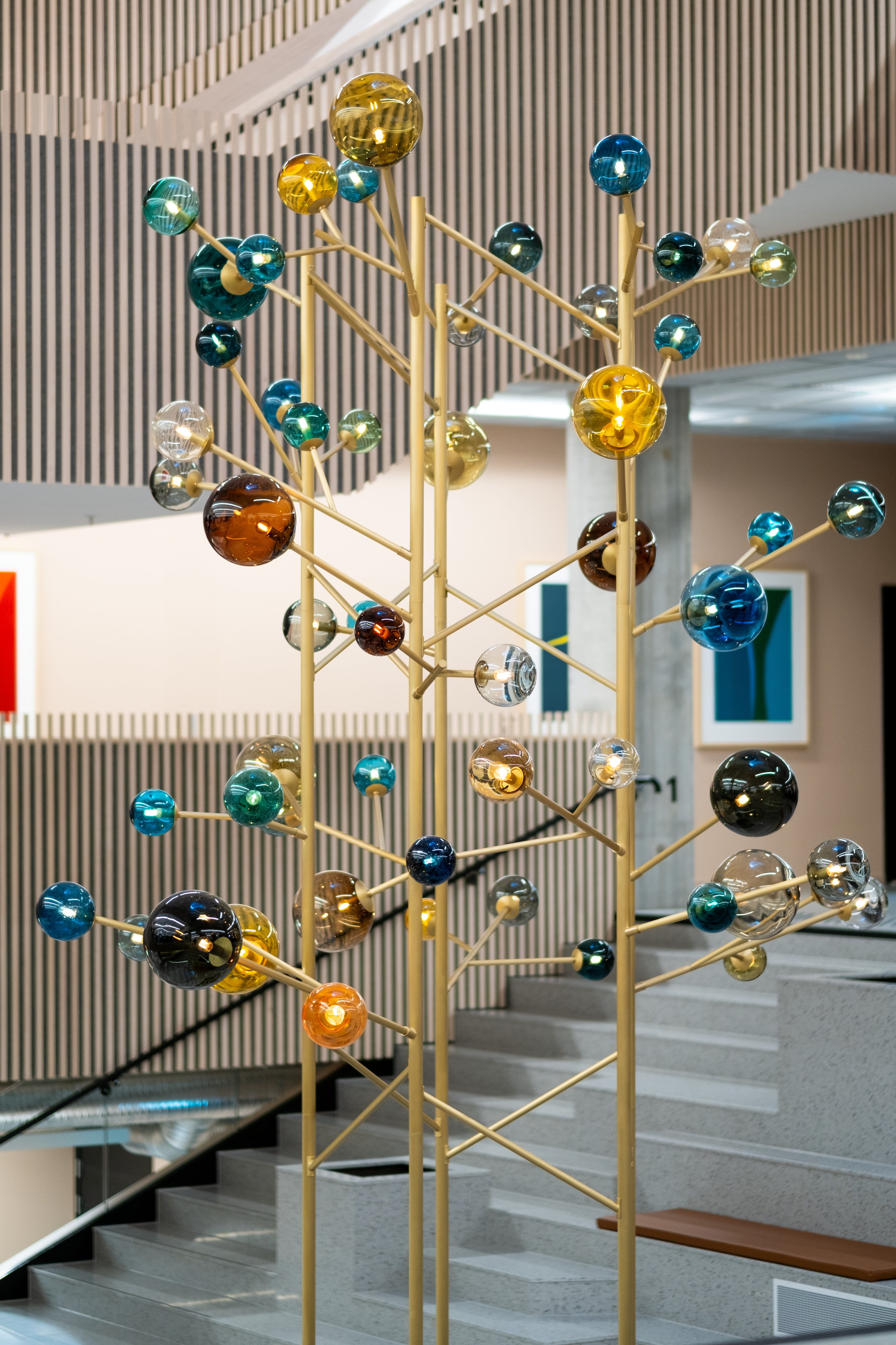 Yggdrasil skulpturen ved Høyskolen Kristiania er designet av Maud Gjeruldsen Bugge – kunstner og designsjef ved Hadeland Glassverk.