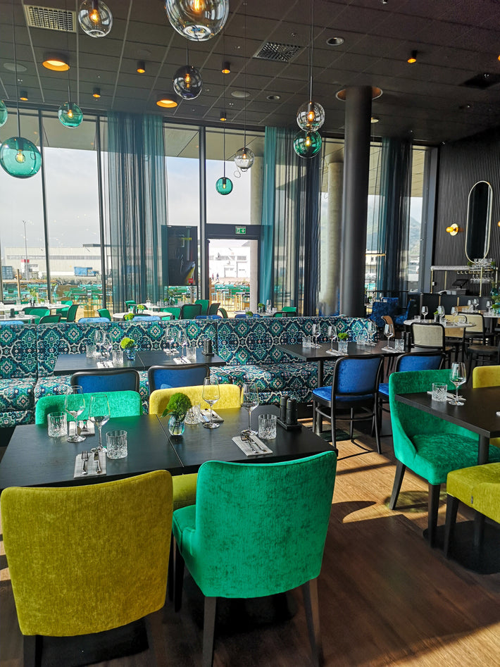 Prisbelønnet Arkiv 4014 pendellamper i ulike farger og størrelser fra Hadeland Glassverk i restauranten på Thon Hotel Svolvær.
