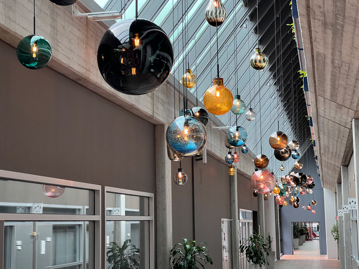 Drops of light kalles installasjonen av munnblåste pendellamper fra Arkiv-serien til Hadeland Glassverk installert i Equinors hovedkontor.